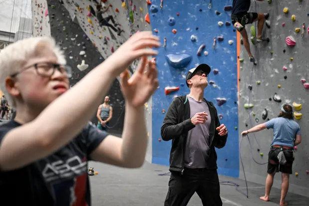 Visually-impaired climber Linn Poston scopes a route alongside their father, Scott, at Movement in Englewood, Colorado, on Tuesday, Feb. 25, 2025. (Photo by AAron Ontiveroz/The Denver Post)
